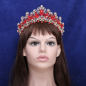 Luxurious vintage gold bridal crown with red crystals and pearls on mannequin head