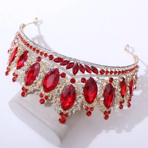 Détail de la couronne baroque dorée avec cristaux rouges sur support en velours