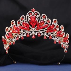 Gros plan d'un diadème de mariée de luxe avec cristaux rouges et monture dorée