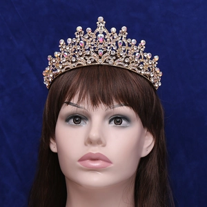 Elegant gold bridal crown with crystal leaf motifs worn by model on navy background