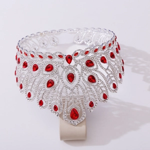 Détail de couronne argentée avec pierres rouges en goutte et plumes de paon en strass