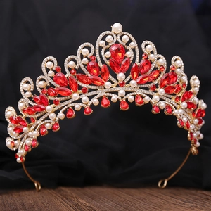 Macro shot of luxury gold bridal crown with red rubies and white pearls detail