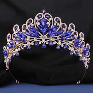 Détail macro du diadème de luxe doré avec gemme bleue en goutte d'eau et diamants blancs