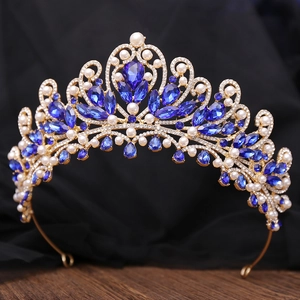 Detailed view of luxury baroque crown with blue crystals and pearls on gold metal frame