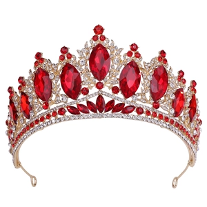 Gros plan sur une couronne dorée avec cristaux marquise rouges et strass blancs