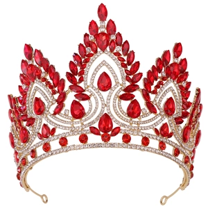 Close-up of golden crown featuring red teardrop crystals and sparkling rhinestones