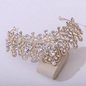 Detailed close-up of a gold bridal crown with crystals and drop-shaped pearls