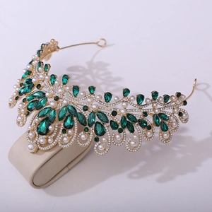 Detail view of gold bridal crown with green teardrop gems and white pearls