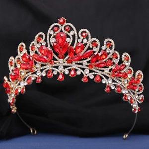Gros plan d'une couronne dorée de luxe avec des gemmes rouges et des cristaux blancs