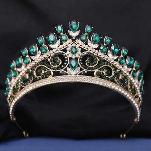 Détail de diadème doré avec strass vert émeraude en forme de goutte d'eau de luxe