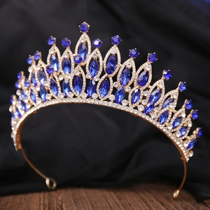 Détails des pierres bleu roi et des cristaux sertis sur la base dorée de cette couronne