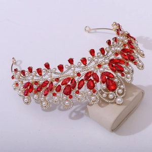 Close-up detail of luxury gold bridal crown with red gemstones and white pearls