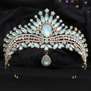 Close-up of a bridal crown with light blue crystals and golden alloy base on black velvet