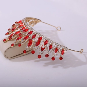 Détail d'une tiare dorée avec pierres marquises rouges et détails en strass blancs
