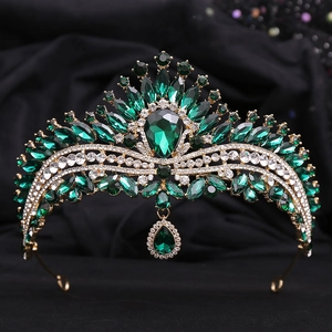 Detailed macro shot of vintage gold crown with emerald green teardrop crystals