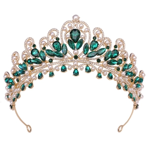 Detailed view of luxury gold bridal crown with emerald crystals and white faux pearls