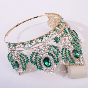 Vue détaillée d'une couronne baroque dorée sertie de cristaux vert émeraude et de gemmes