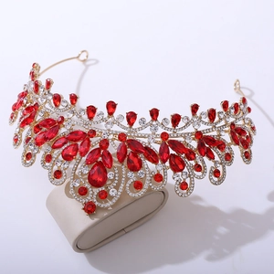 Détail d'une couronne dorée de luxe avec cristaux rouges en poire et gemmes claires