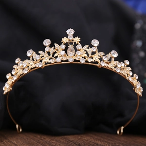 Macro detail of gold bridal tiara featuring teardrop crystal and floral rhinestones