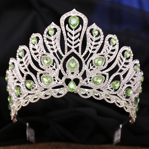 Regal silver pageant crown featuring sparkling rhinestones and emerald green gemstones
