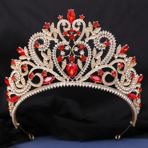Vue détaillée d'une couronne baroque dorée avec strass rouges en cœur et cristaux
