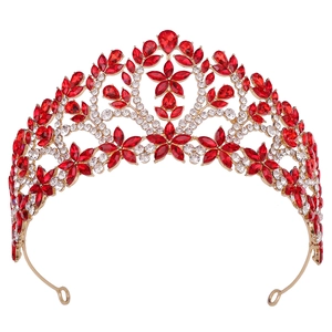 Détails de la tiare baroque dorée avec cristaux rouges en cœur et motifs de strass floraux