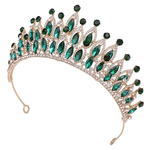 Détails d'une couronne de mariée dorée avec gemmes vert émeraude et strass scintillants