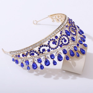 Détail de diadème de mariée doré avec cristaux bleus en goutte et motifs ajourés sophistiqués
