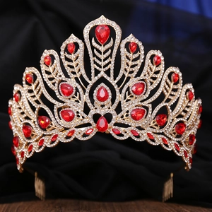 Detailed close-up of golden crown with red teardrop gemstones and white zircons