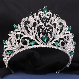 Gros plan détaillé d'un diadème baroque argenté avec gemmes vertes et strass brillants
