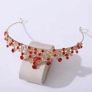 Detailed view of vintage gold bridal crown with red rhinestones and teardrop crystal