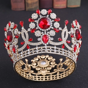 Detalle de la corona barroca dorada con piedras preciosas rojas y cristales brillantes