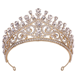 Détail d'une couronne de mariée dorée avec gouttes en cristal et anneaux latéraux