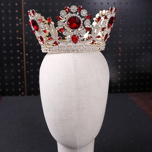 Detalle de la lujosa corona de novia dorada con cristales de rubí rojo y diamantes imitación