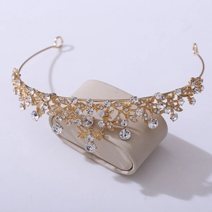 Detail of a golden bridal crown featuring intricate vine patterns and sparkling rhinestones
