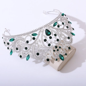 Détails macro de la couronne baroque argentée avec strass verts en forme de poire