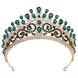Détail d'une couronne vintage en alliage doré avec cristaux émeraude et motif ajouré complexe