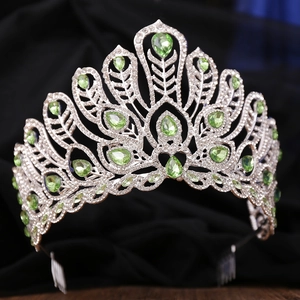 Detailed macro view of a silver pageant tiara featuring green pear-cut crystals and side combs