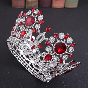 Detalle de lujosa corona de novia plateada con piedras preciosas rojas y cristales