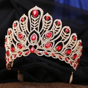 Detail of a large gold pageant crown with red teardrop gemstones and clear rhinestones