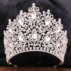 Close-up of luxury bridal crown featuring silver leaves and sparkling crystals on dark mesh