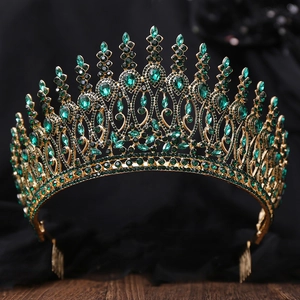 Detailed view of Baroque gold crown with emerald green rhinestones and hair comb attachment