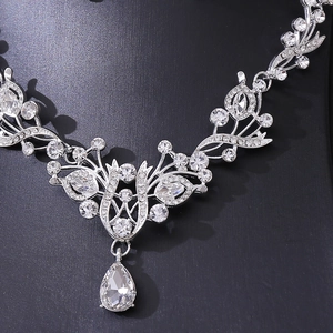 Macro shot of sparkling silver crystal bridal necklace with pear-shaped pendant on black stand