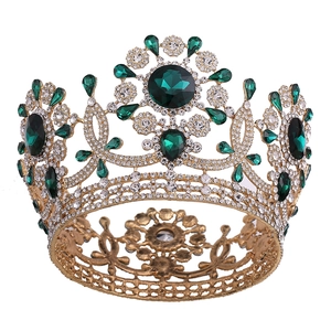 Detalle de la corona dorada vintage con cristales verde esmeralda y brillantes strass