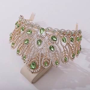 Detailed close-up of golden pageant crown with green pear-shaped gems and white crystals