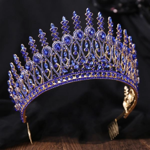Close-up of golden baroque tiara with blue rhinestones and integrated hair comb