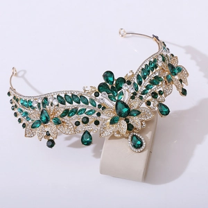 Detail of floral alloy bridal crown with deep green rhinestones and gold base