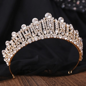 Close-up of golden bridal crown with sparkling crystal rhinestones on a dark base