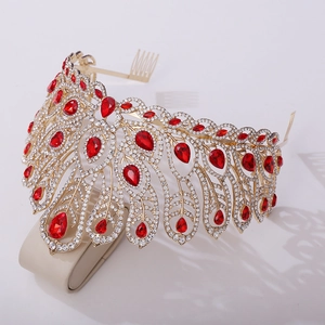 Detailed side view of baroque gold crown with sparkling white diamonds and red teardrop gems
