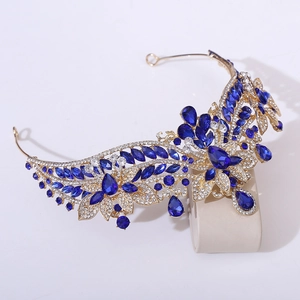 Macro detail of royal gold wedding tiara with deep blue crystals and floral diamond accents